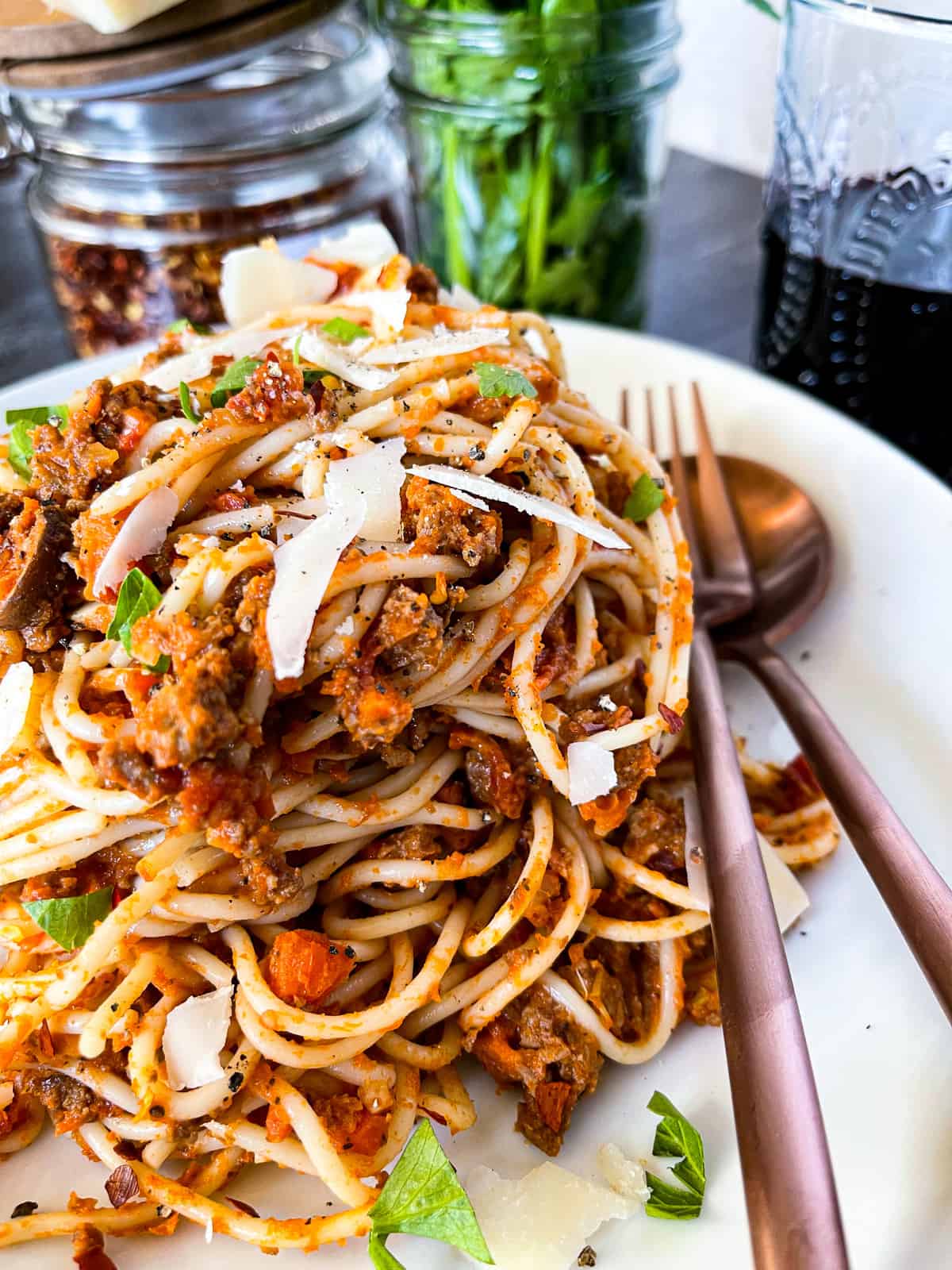 bolognese sauce tossed with spaghetti noodles and topped with parmesan cheese