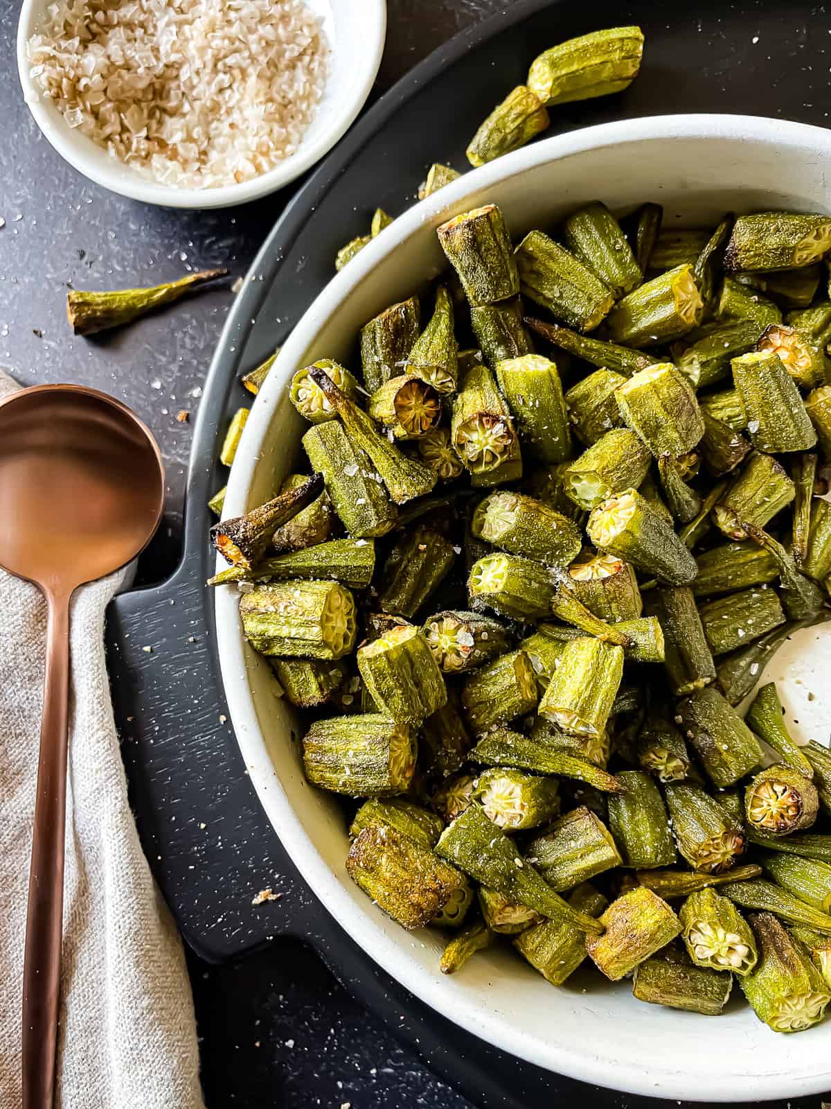 bowl of air fryer okra recipe garnished with black pepper and smoked sea salt