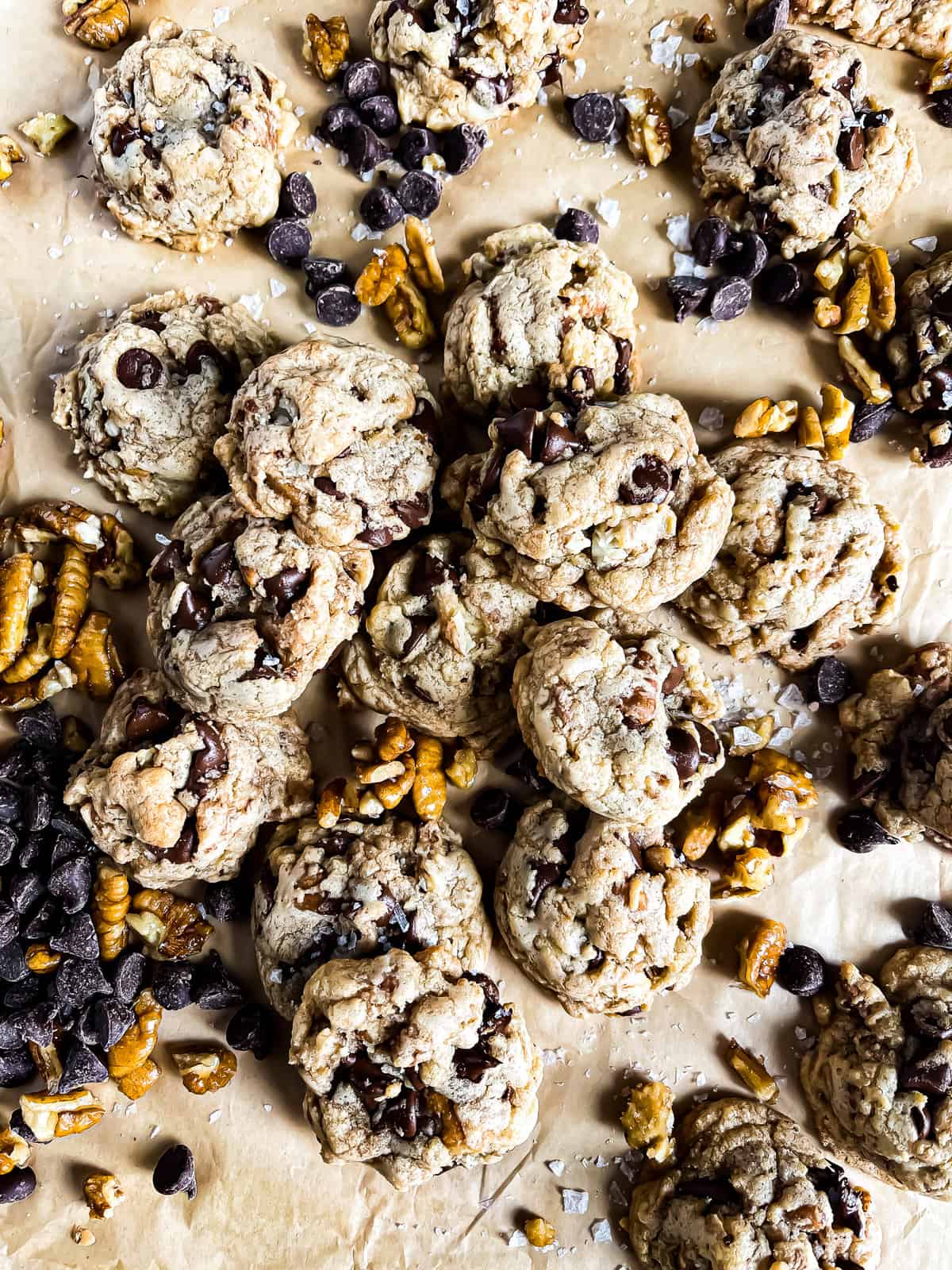 picture of a mound of brown butter chocolate chip cookies with extra pecan and choc chip garnishes - dessert portion of the super bowl recipe roundup