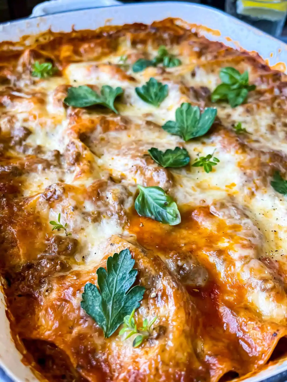 creamy pesto ricotta lasagna with fresh herb garnishes