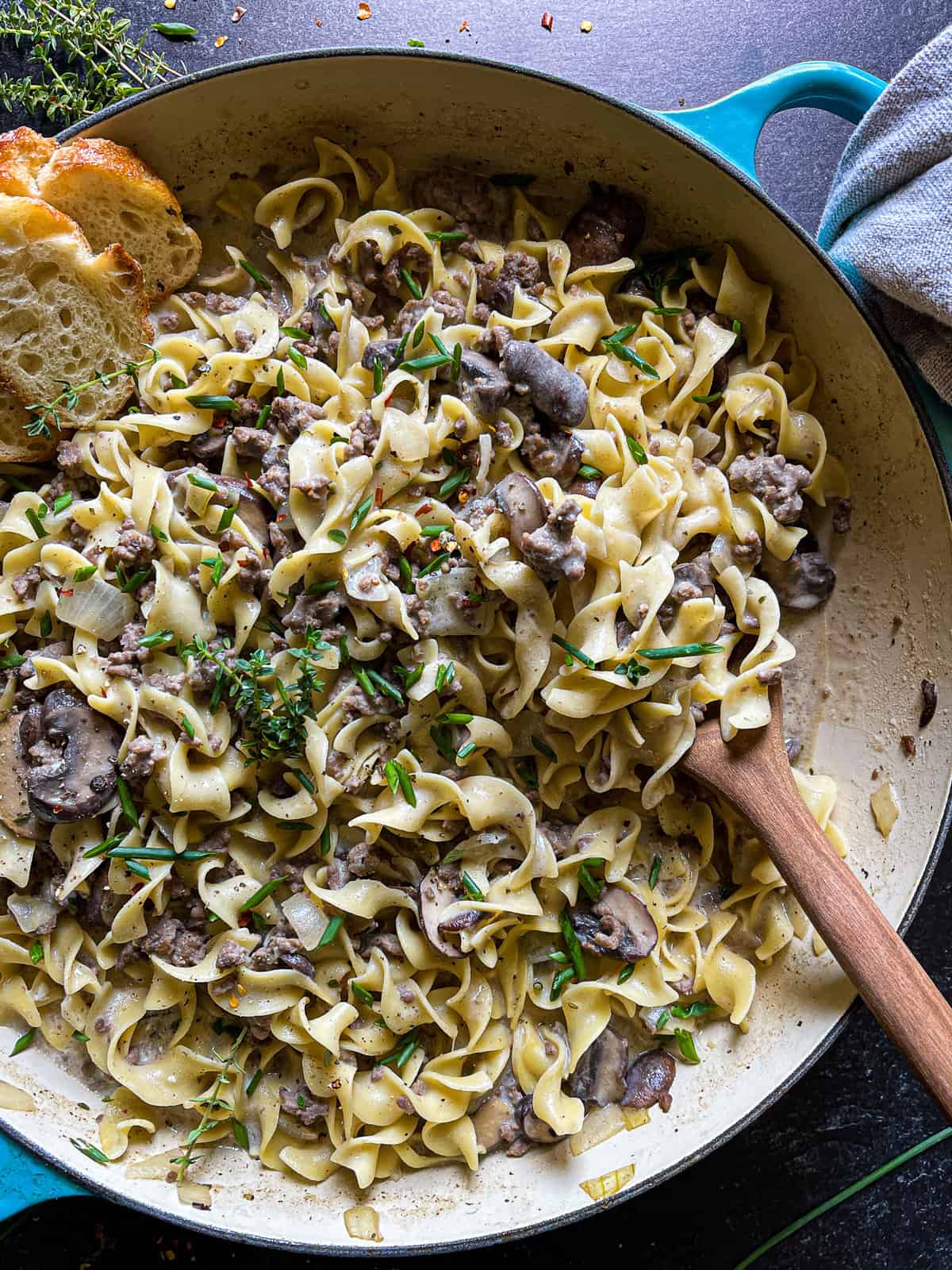 ground beef stroganoff in a large braiser, garnished with chives and thyme