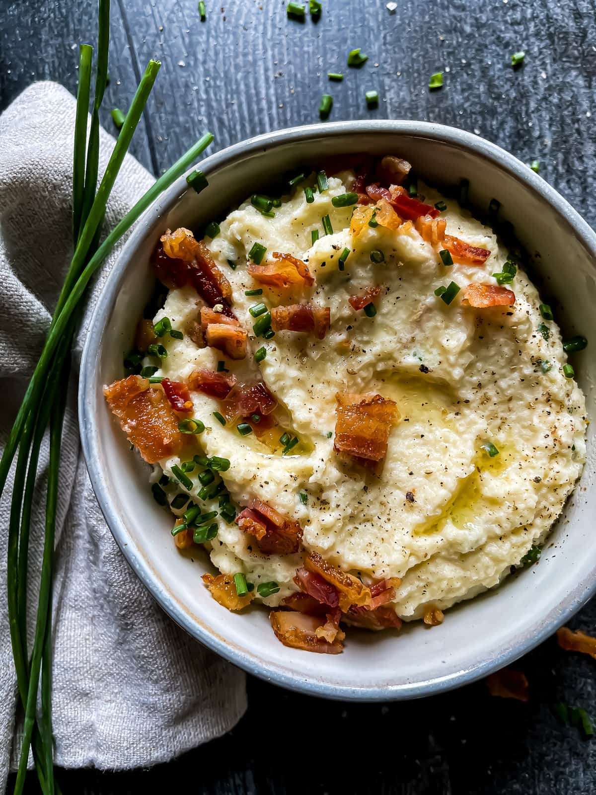 mashed cauliflower garnished with chives, bacon