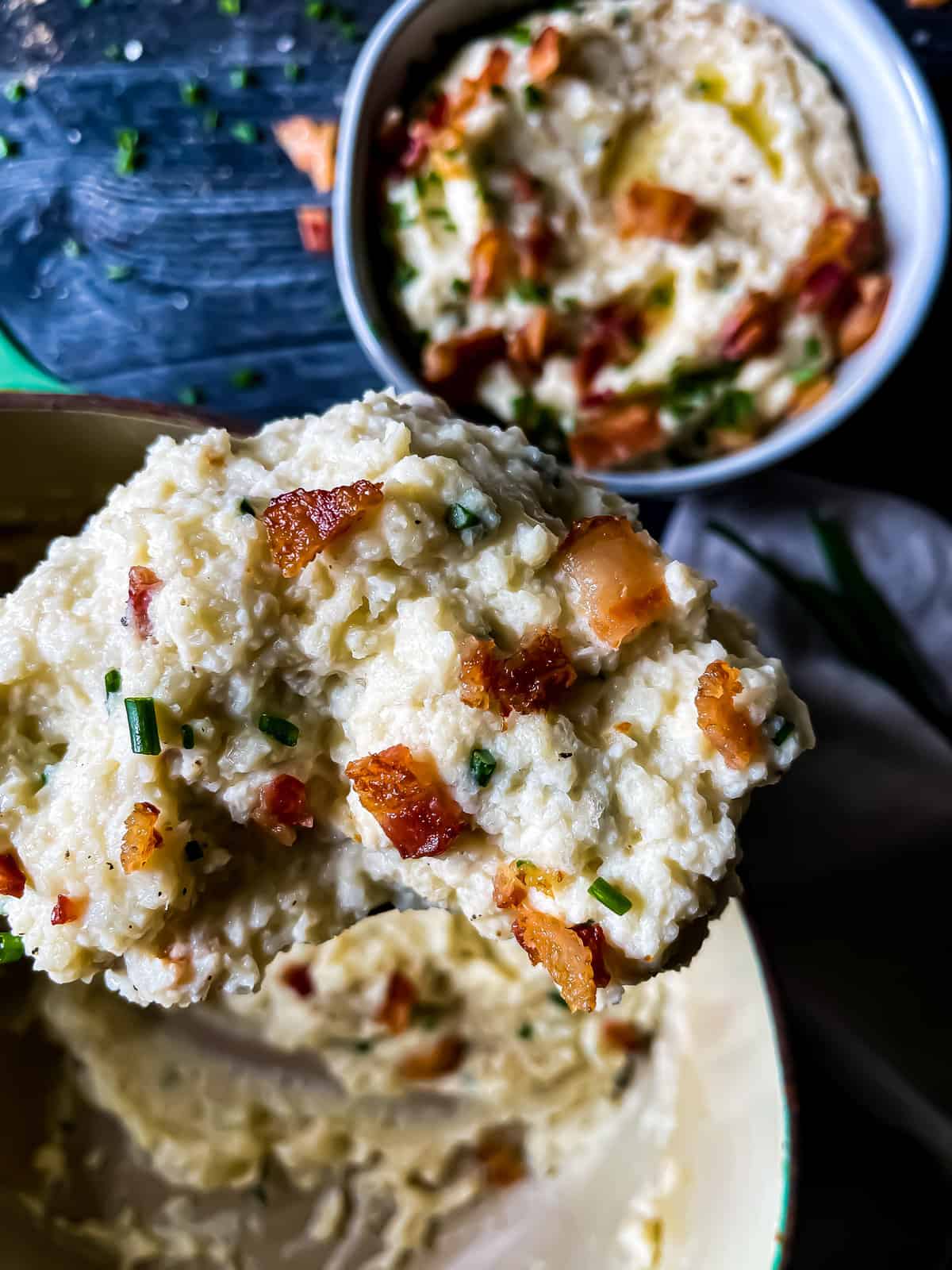 mashed cauliflower garnished with chives, bacon
