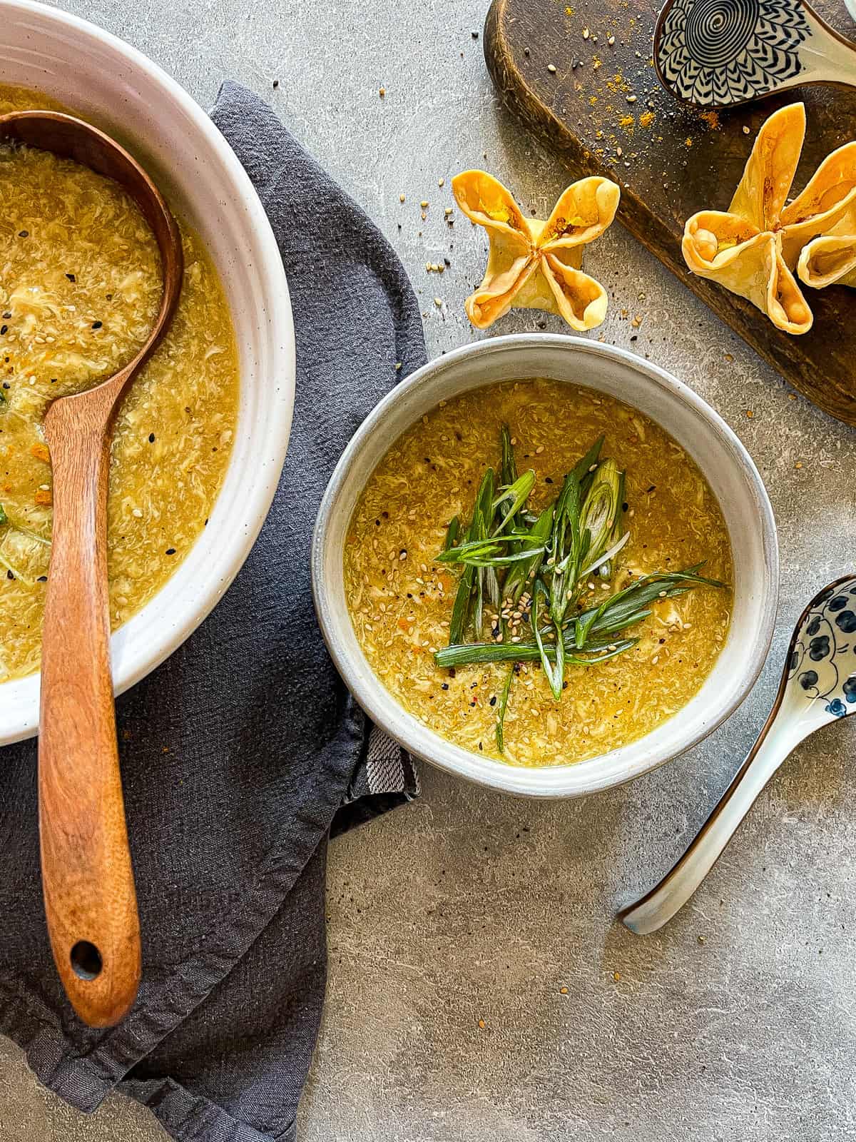 egg drop soup, served in a bowl with a side of wontons