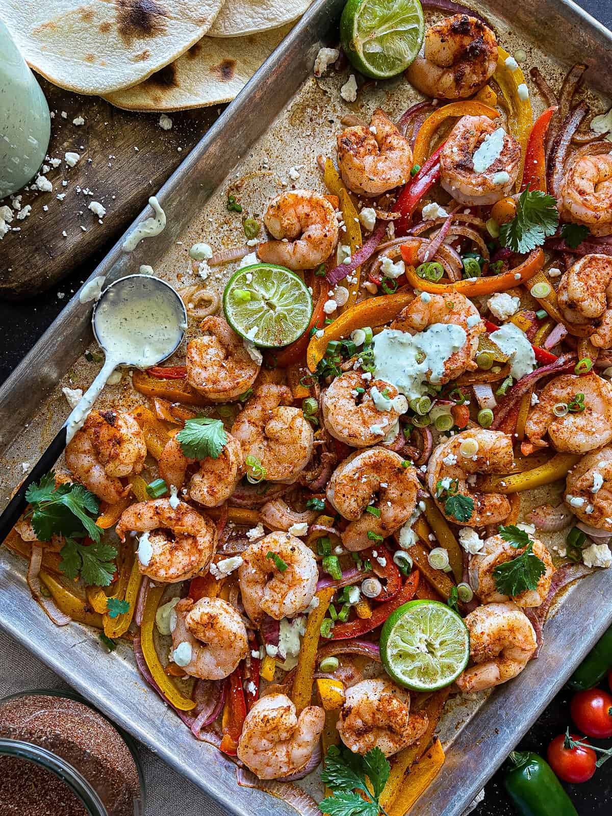 shrimp on a baking sheet with mexican spices, roasted veggies, and a tangy ranch