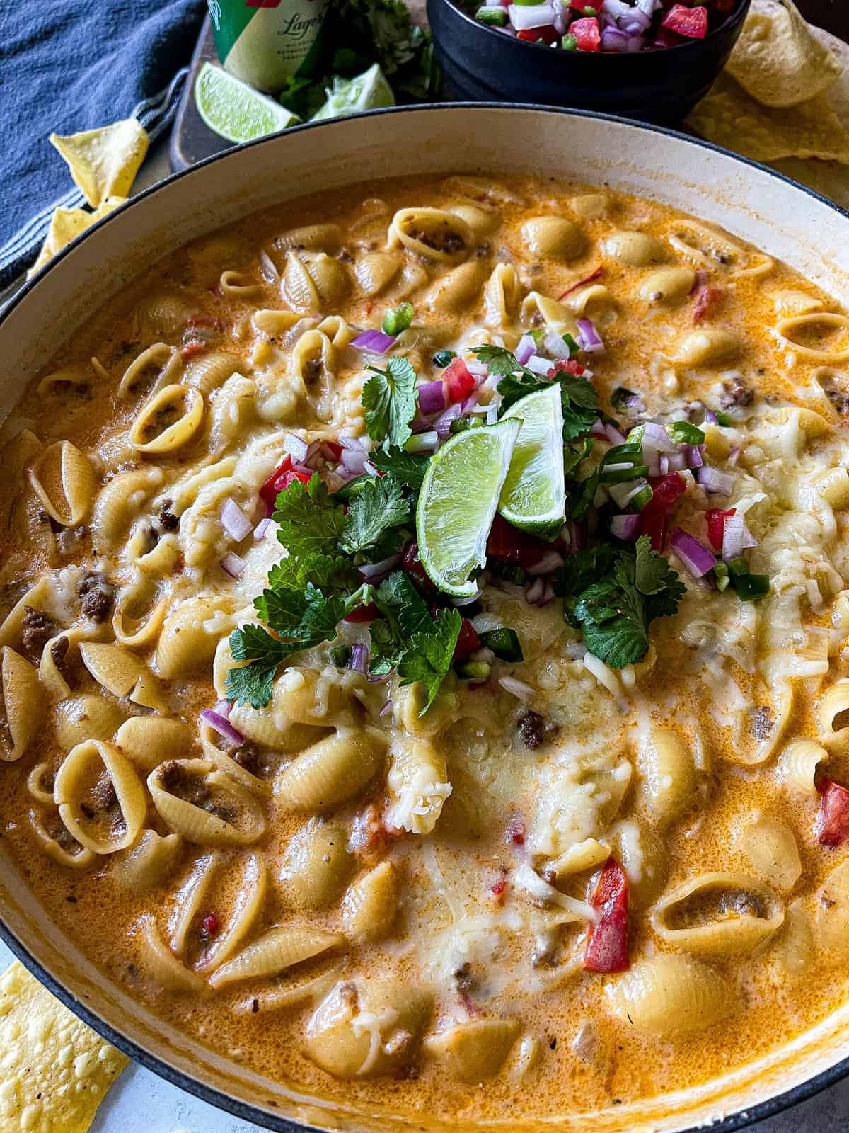 cheesy taco pasta garnished with cilantro and pico de gallo