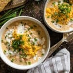 ham and potato soup in white bowls on a wooden background