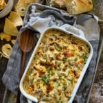 philly cheesesteak dip in a baking dish and garnished with chips and crusty bread for dipping