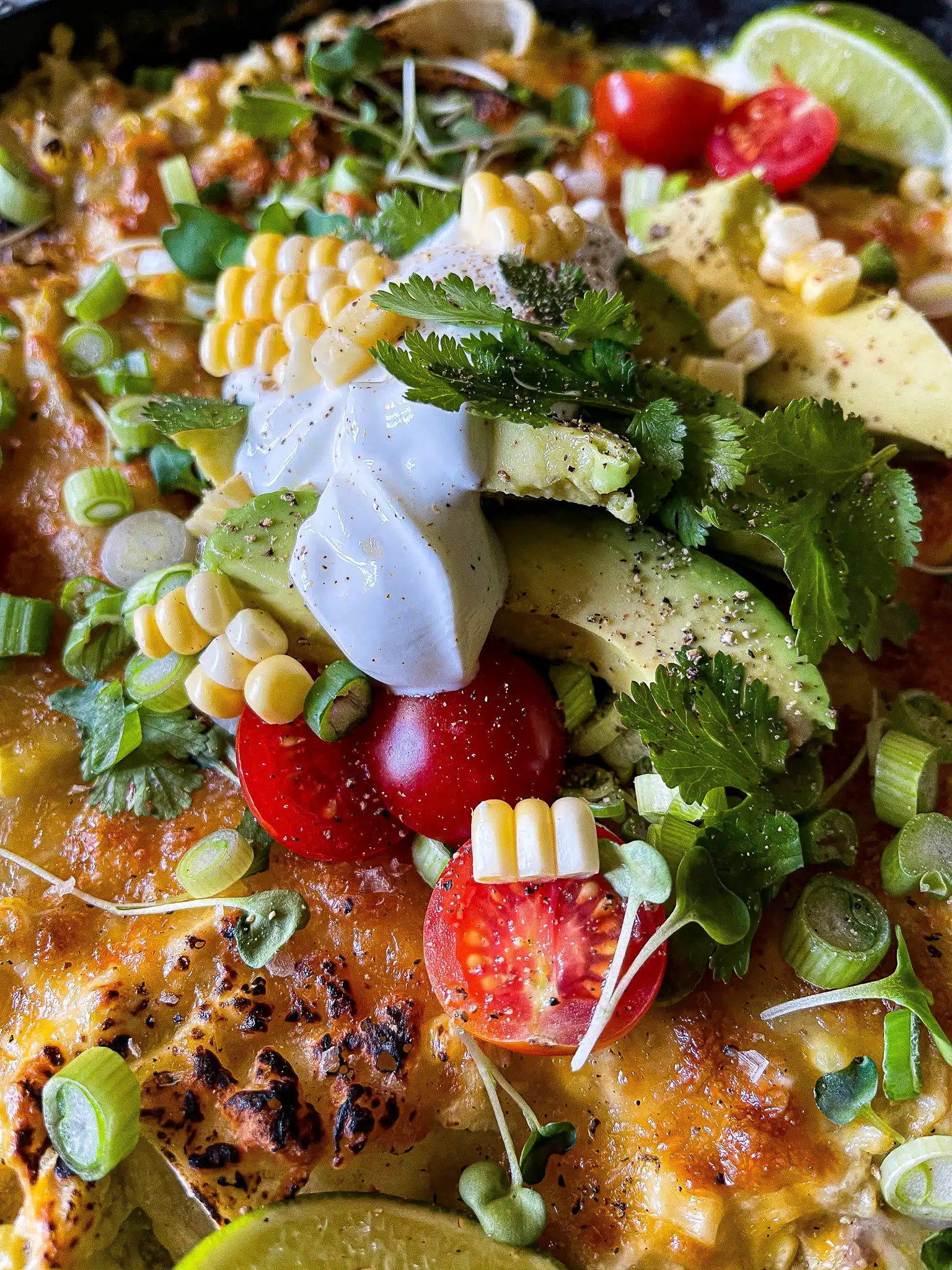 sour cream, avocado, cilantro, tomatoes, micro greens, and sweet corn for garnish