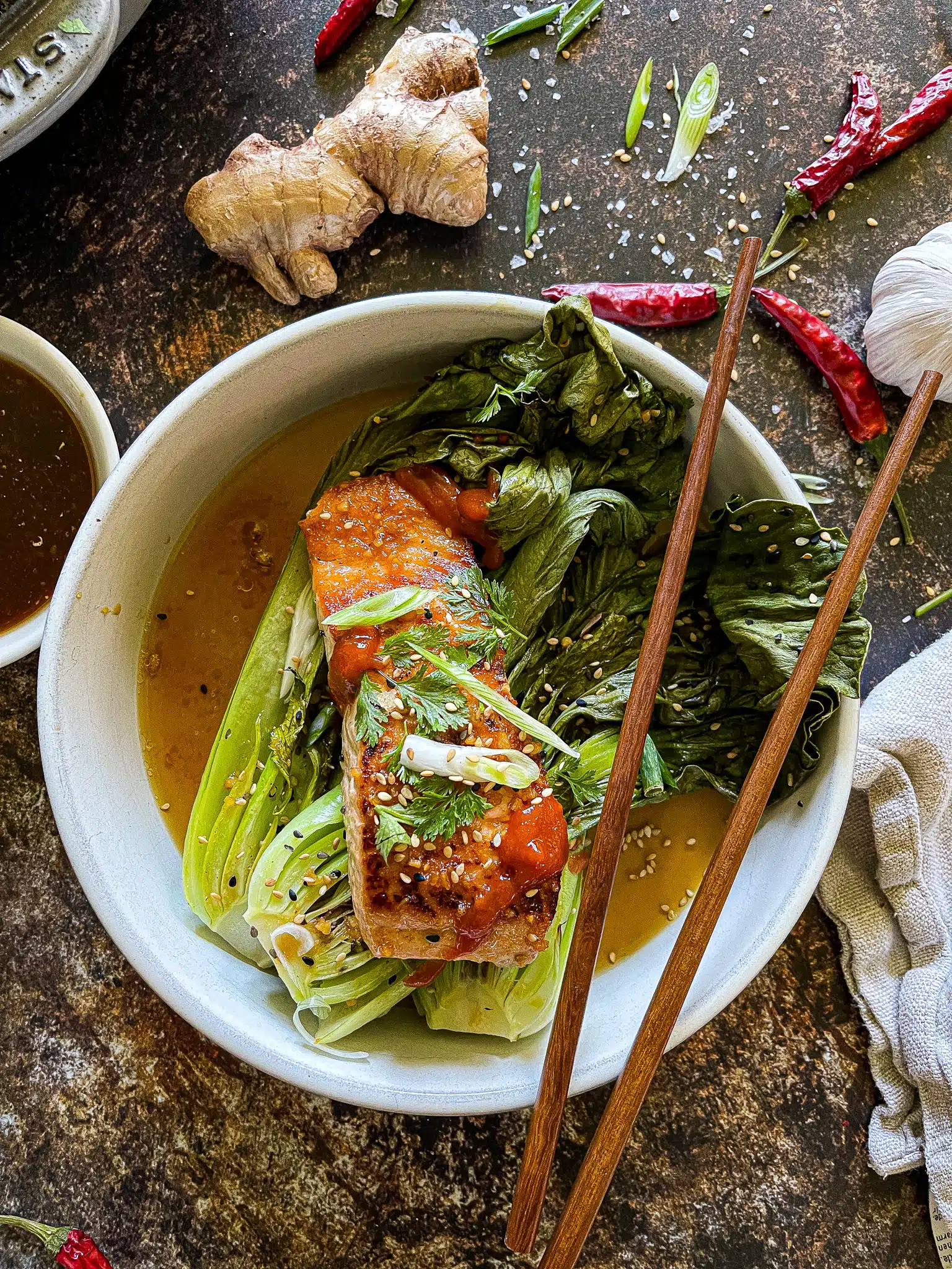 soy ginger salmon served with roasted bok choy, garnished with cilantro, green onion, and sesame seeds