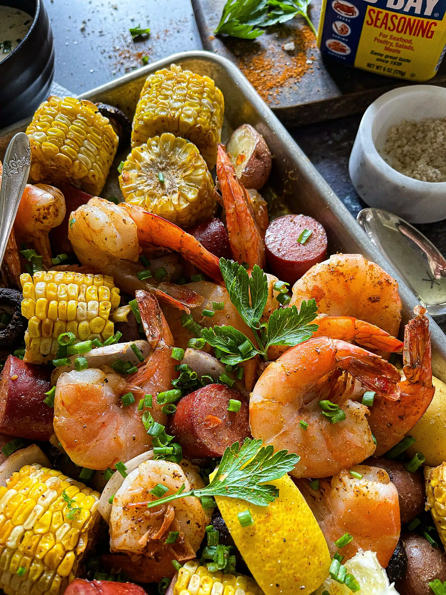 shrimp, potatoes, corn, mushrooms, and sausage roasted on a sheet pan with a side of remoulade