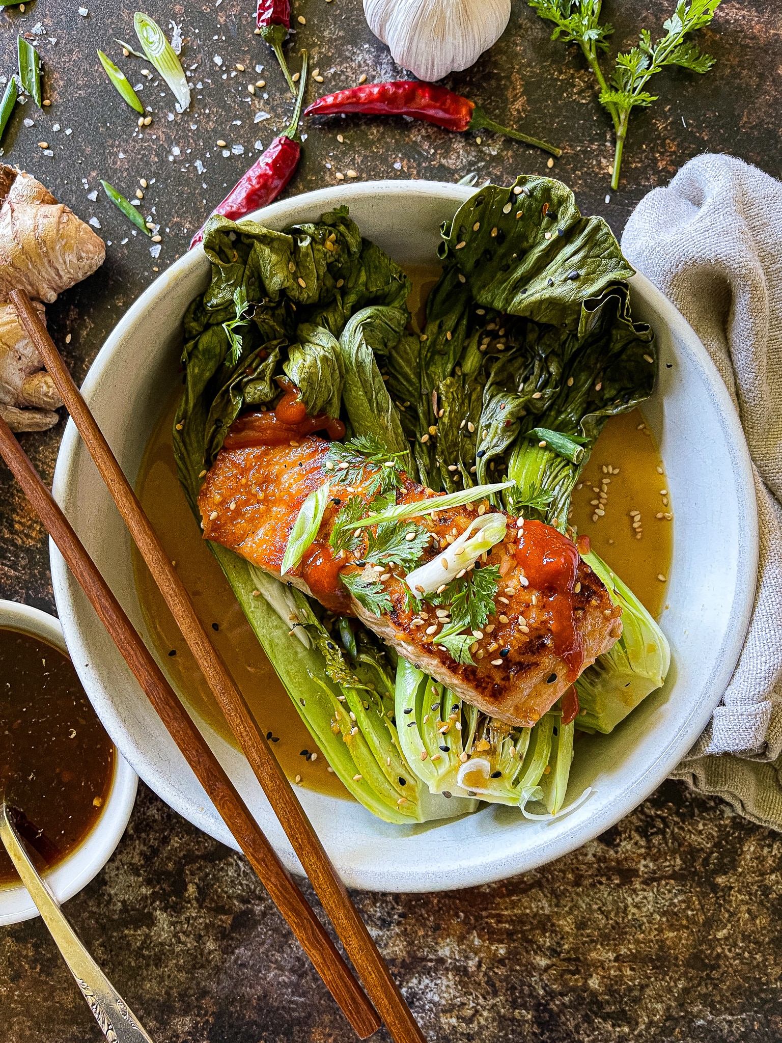 soy ginger salmon served with roasted bok choy, garnished with cilantro, green onion, and sesame seeds