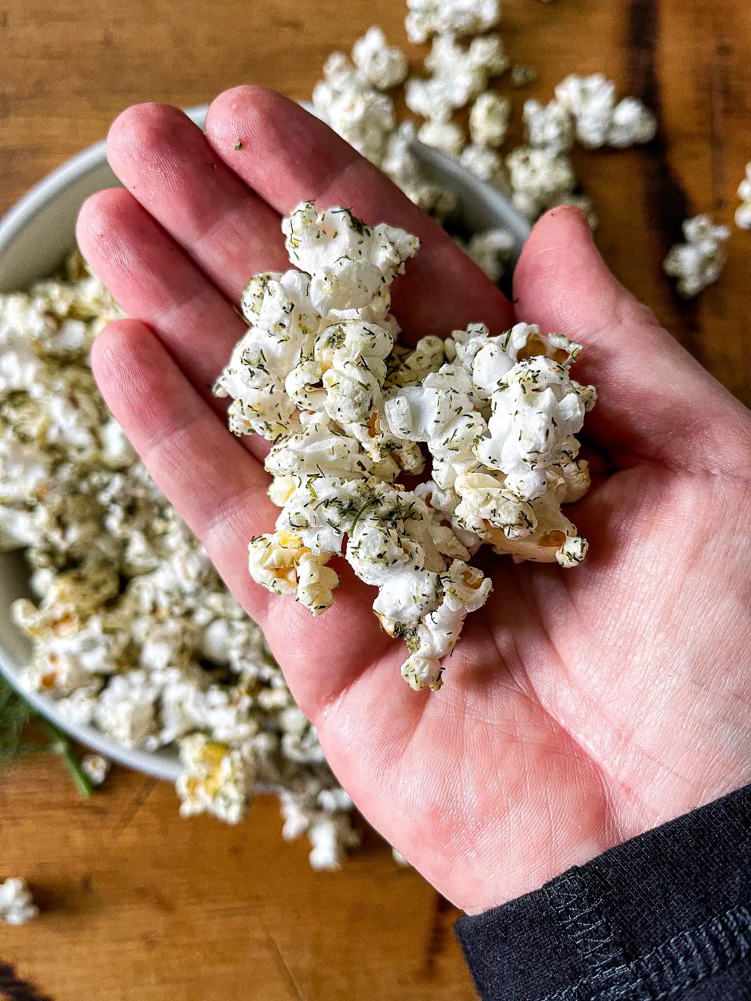 a large handful of dill pickle popcorn