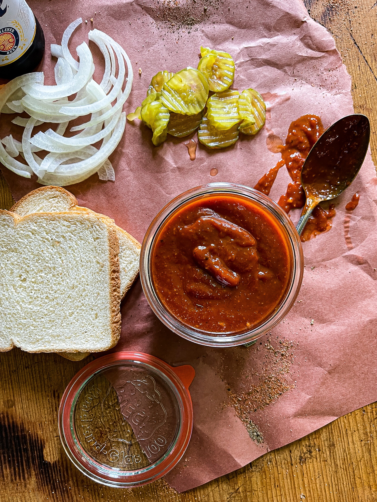 bbq sauce served with sliced bread, onions, and pickles