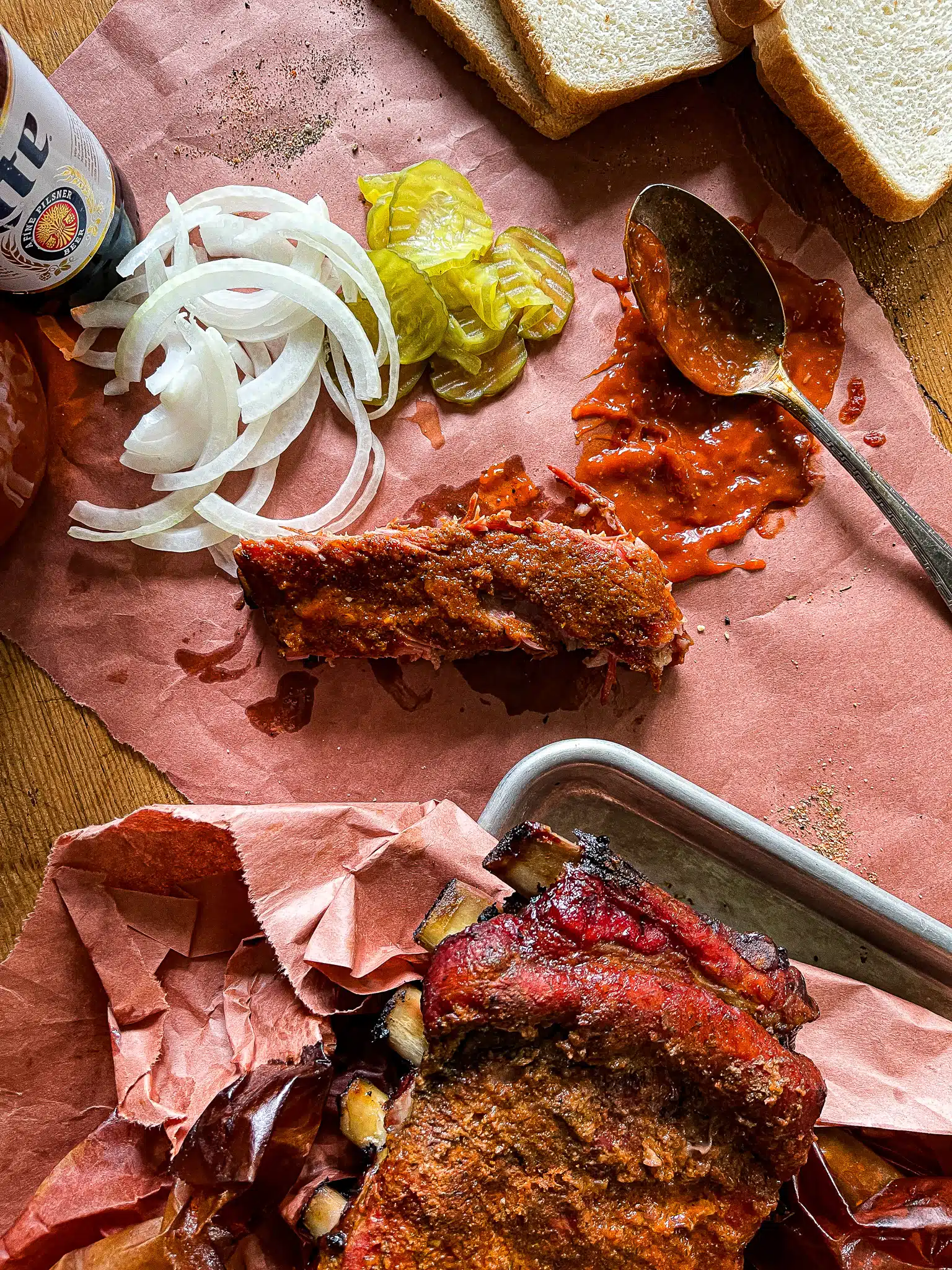 a cut pork rib served with sliced onions and pickles