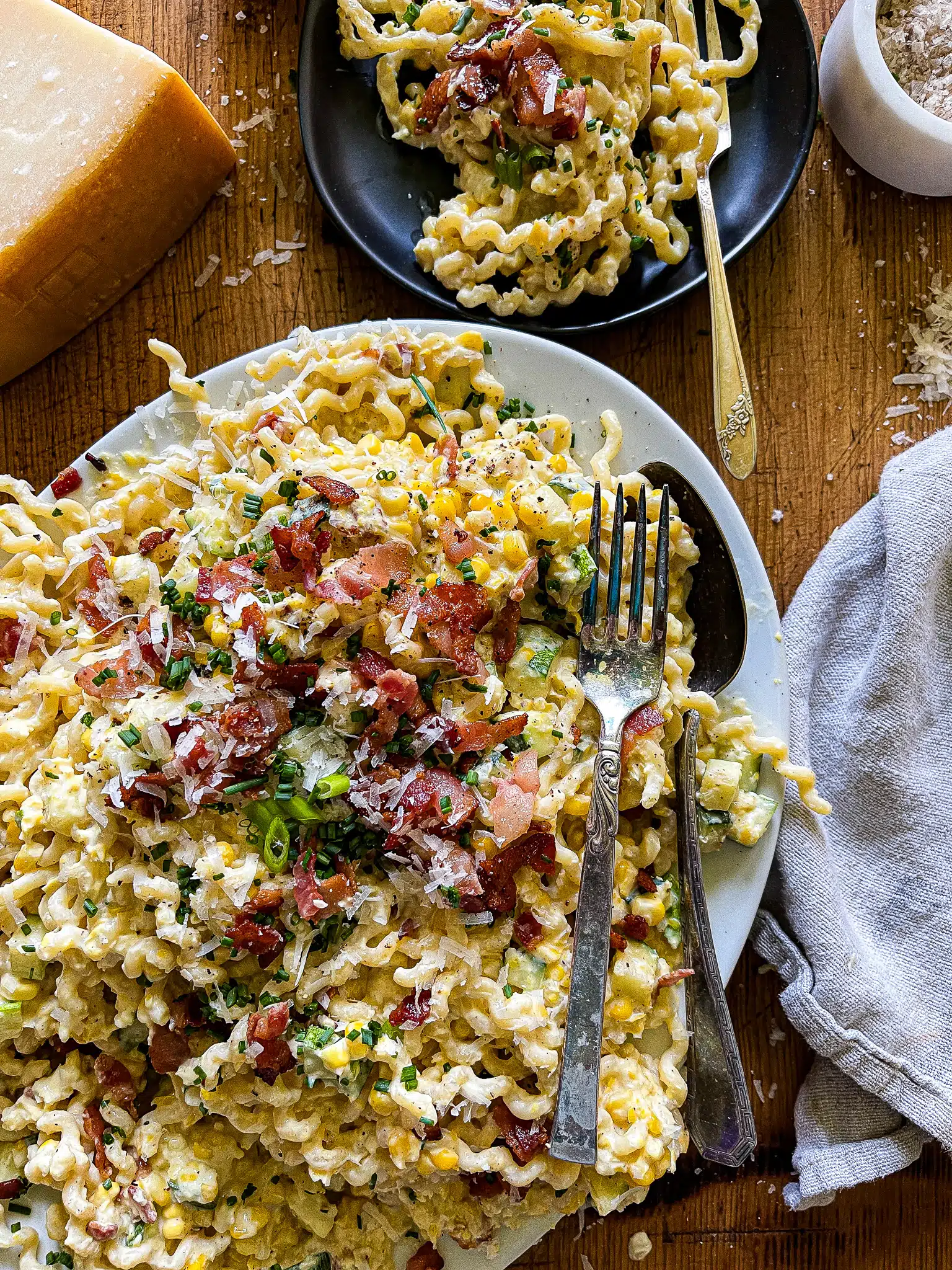 sweet corn pasta garnished with bacon, chives, and parmesan