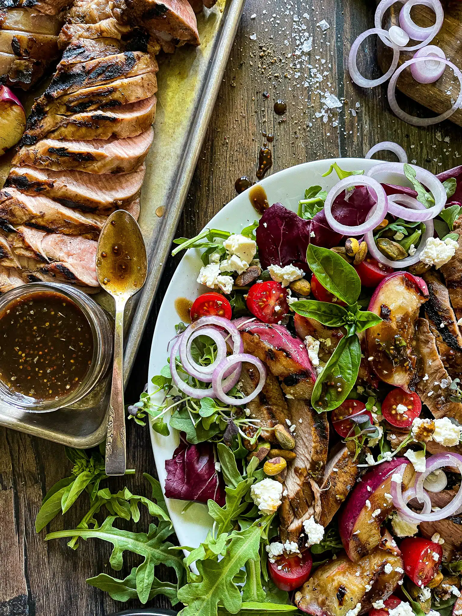 grilled peach salad with a side of sliced pork tenderloin