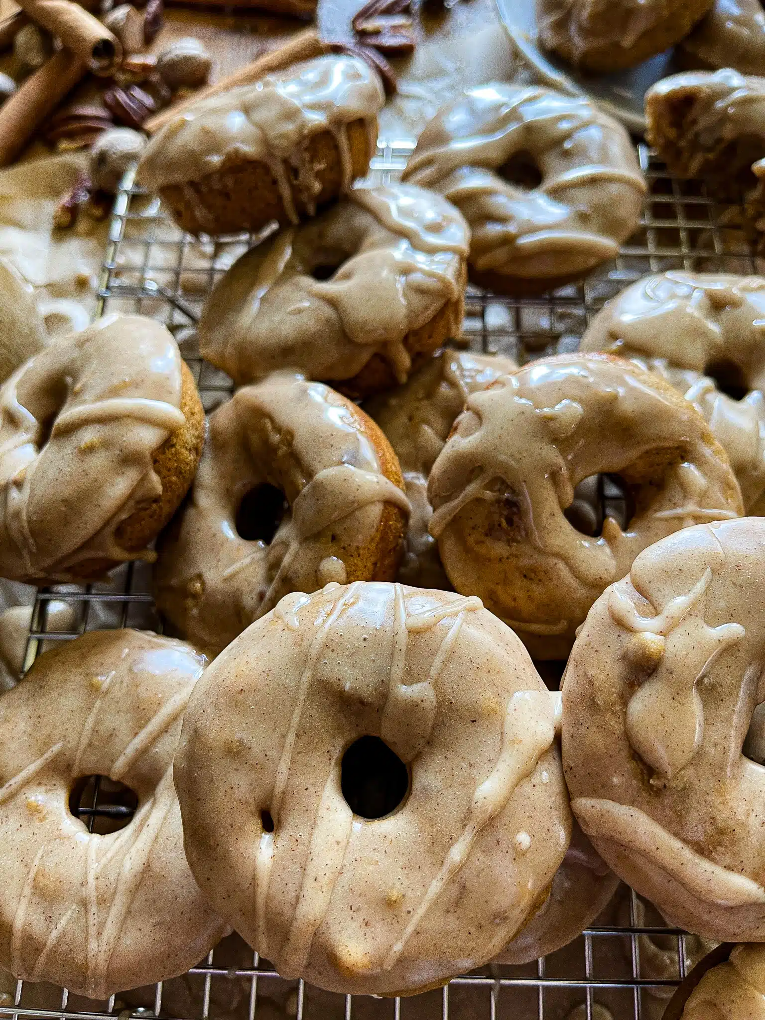 This is a photo of a pile of apple cider donuts with a maple cinnamon glaze.