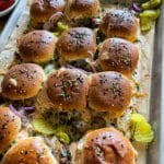This is a picture of a sheet pan of cheeseburger sliders with gooey cheese and burger sauce.
