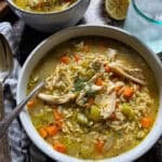 This is a picture of Greek Lemon Chicken Orzo soup garnished with fresh dill.
