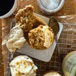 Fresh-baked banana bread with vanilla ice cream and caramel drizzle, served with coffee and salted caramel sauce on a wooden table, delicious dessert plate.