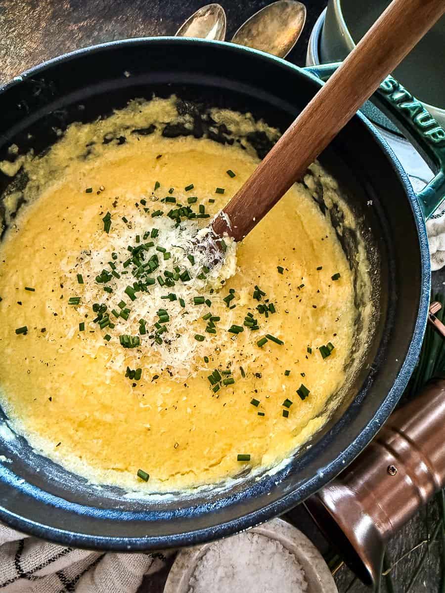 Bowl of creamy, golden polenta topped with butter and herbs — silky, rich, and perfect for cozy dinners