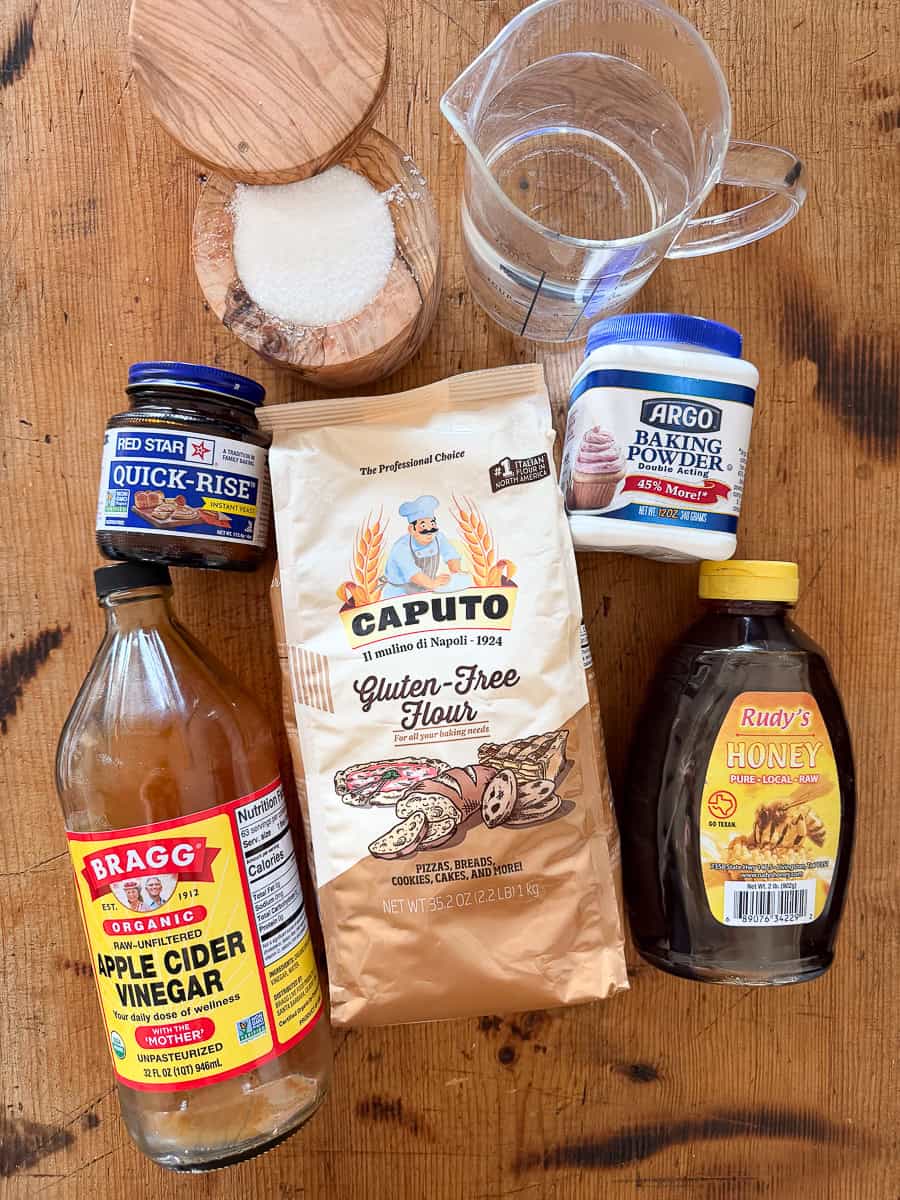 ingredients laid out on a wooden surface for a gluten-free no-knead bread recipe