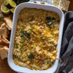 Baking dish with crab & artichoke dip with toasted breadcrumbs and fresh herb garnish