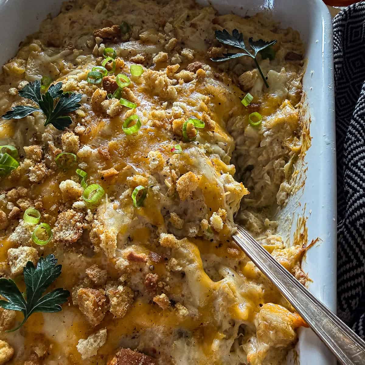 Baking dish with crab & artichoke dip with toasted breadcrumbs and fresh herb garnish