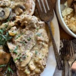 slow cooker smothered pork chops garnished with fresh herbs