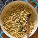 cafeteria noodles in large braiser with a wooden spoon