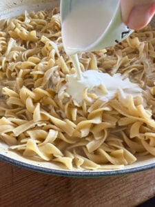 heavy cream being pour into cafeteria noodles