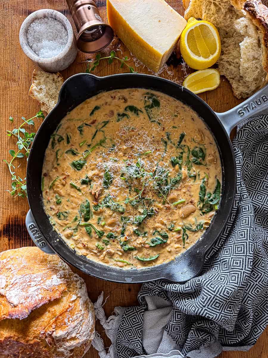 marry me butter beans in a cast iron skillet garnished with fresh herbs