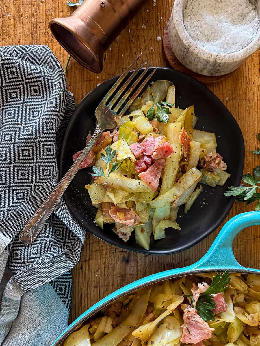 sautéed cabbage on a black plate on top of a wooden surface