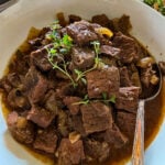 slow cooker steak bites in a white serving bowls
