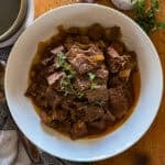 slow cooker steak bites in a white serving bowl