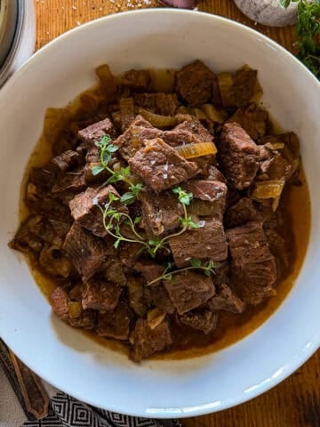 slow cooker steak bites in a white serving bowl