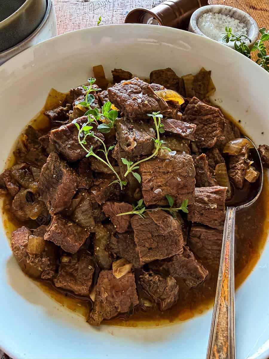 slow cooker steak bites in a white serving bowls